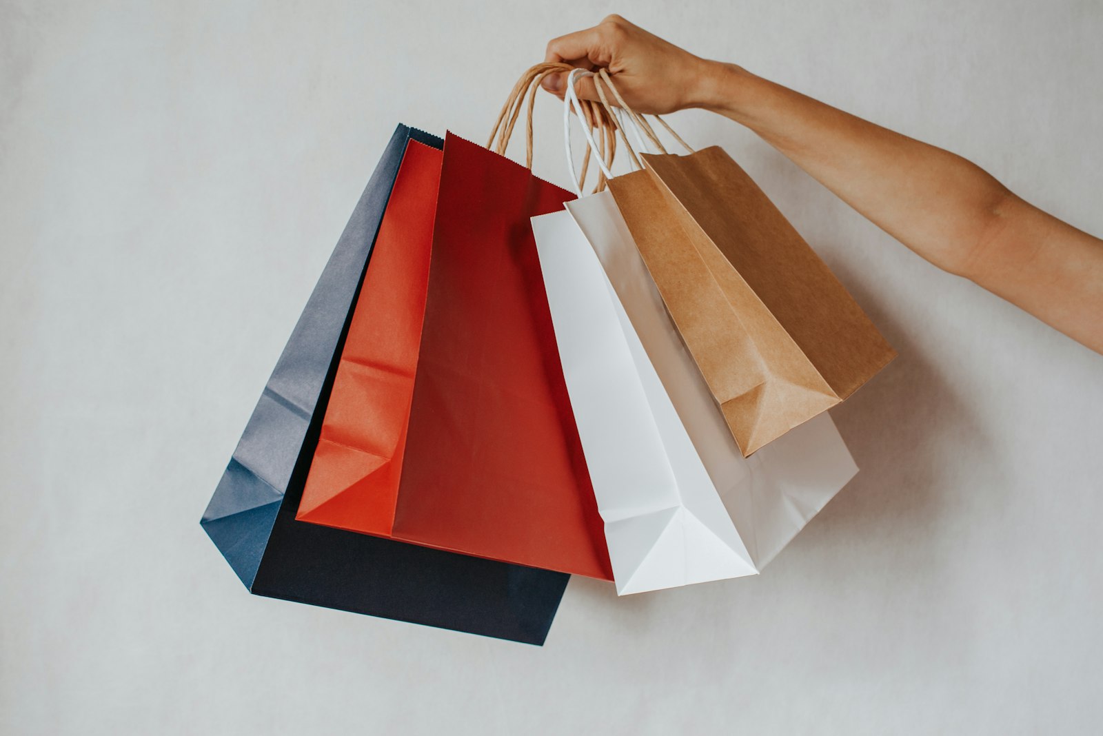 Sacos de compras coloridos numa mão, representando a época de compras da Black Friday